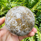 Side angle of Ocean Jasper polished sphere, from Sofia, Madagascar, showing translucent edges.