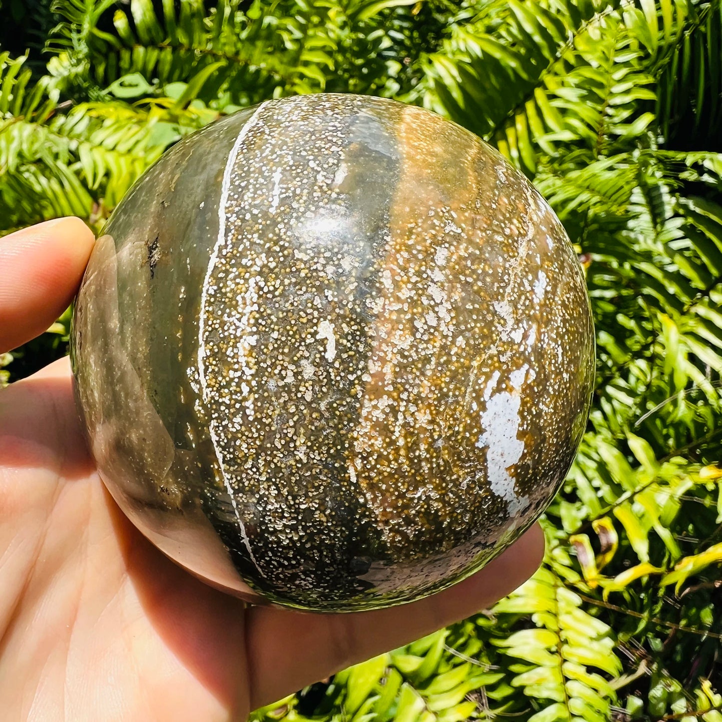 Hand-scale shot of a Ocean Jasper polished sphere for Emotional Healing.