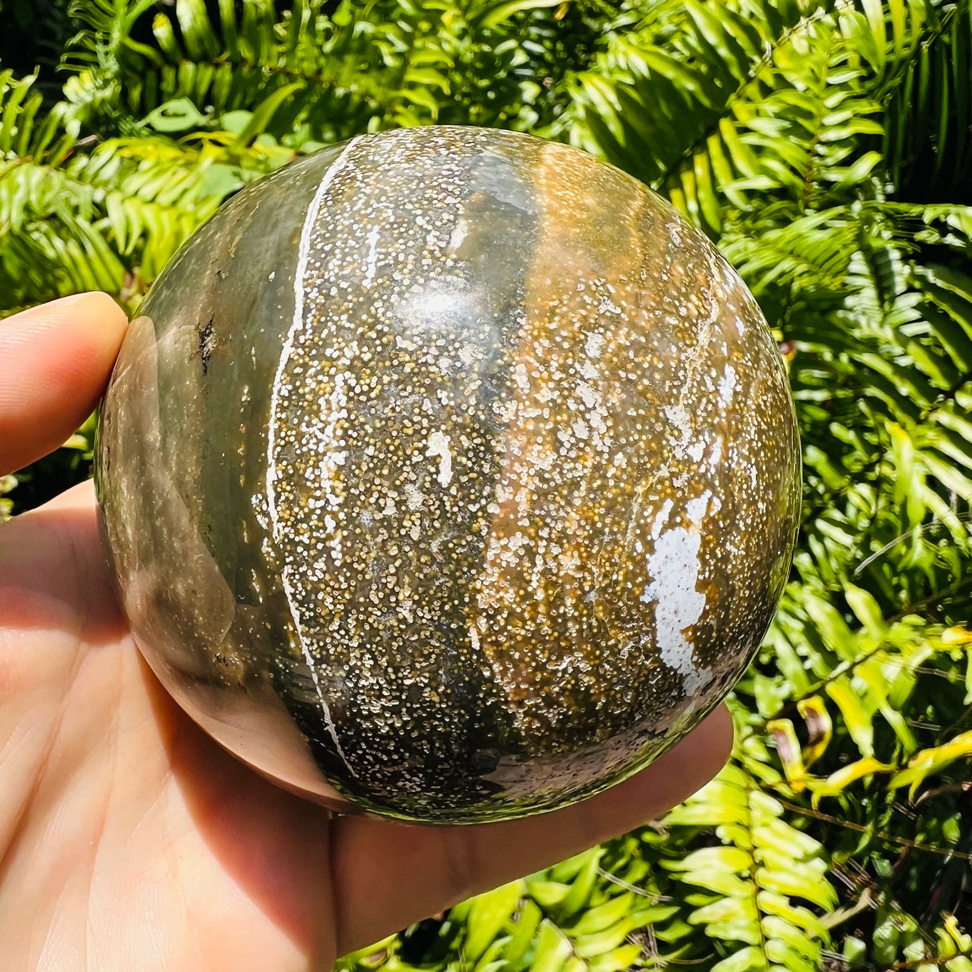 Hand-scale shot of a Ocean Jasper polished sphere for Emotional Healing.