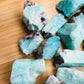 Overhead view of Grade AA Amazonite raw stone, hand-selected from Amboasitra, Madagascar, worked with for Stress Relief.
