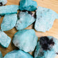 Hand-held view of a single Amazonite raw stone hand-selected from Amboasitra, Madagascar.