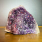Grade aa amethyst geode held in hand for size reference