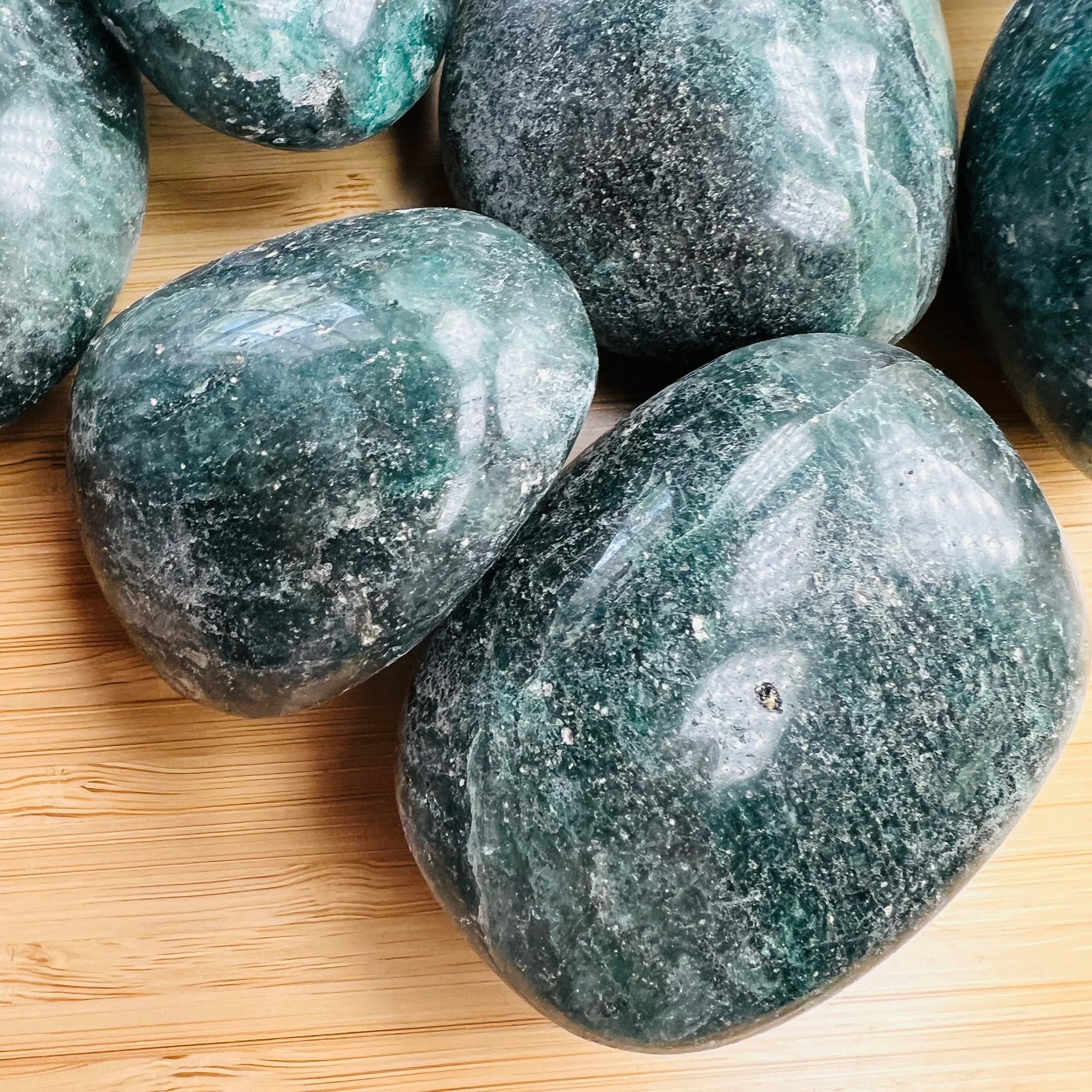 Looking down on Grade AA Fuchsite palm stone, showing natural sheen, from Madagascar.