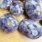 Side profile of Chevron Amethyst palm stone, showing earthy tone, associated with Intuition.