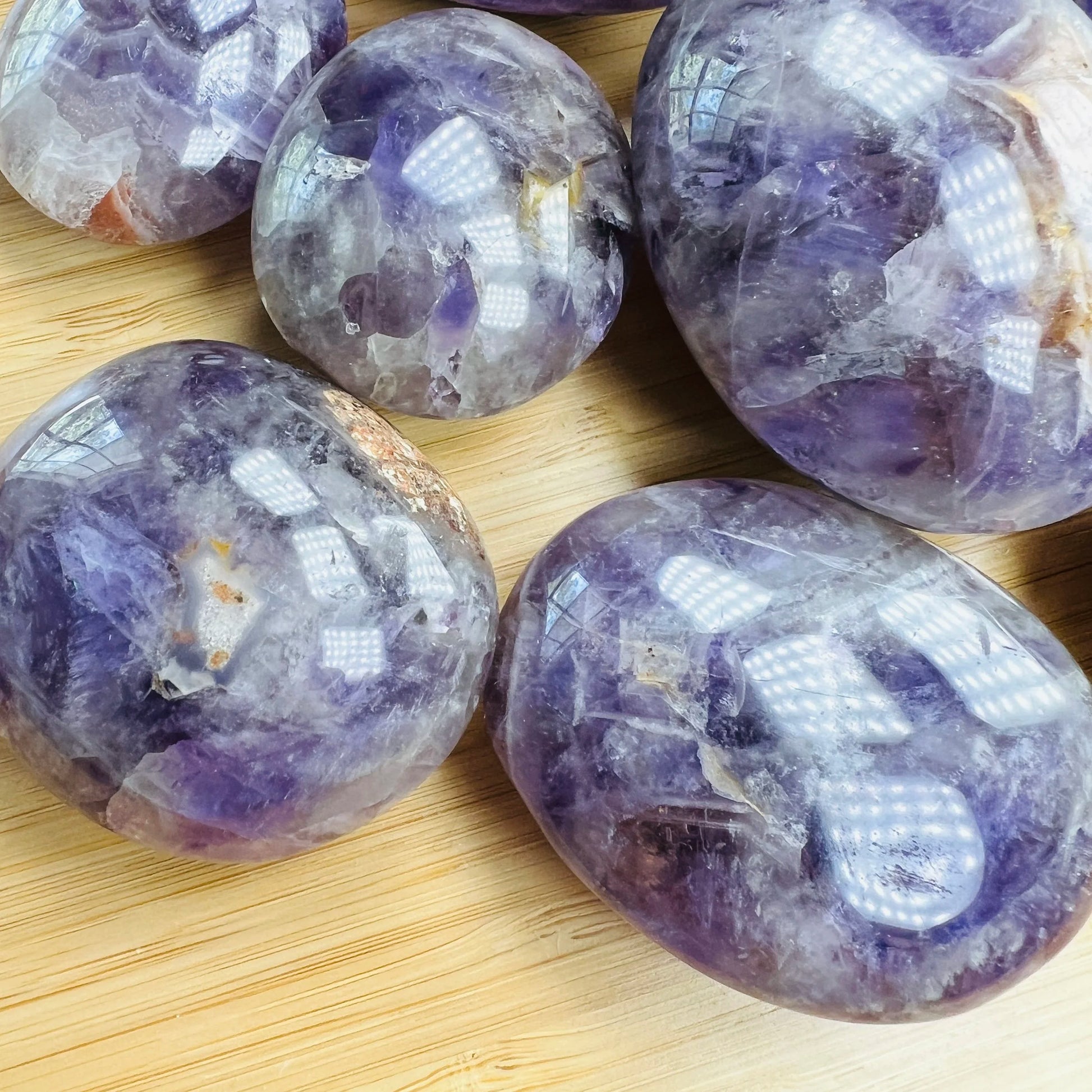 Side profile of Chevron Amethyst palm stone, showing earthy tone, associated with Intuition.
