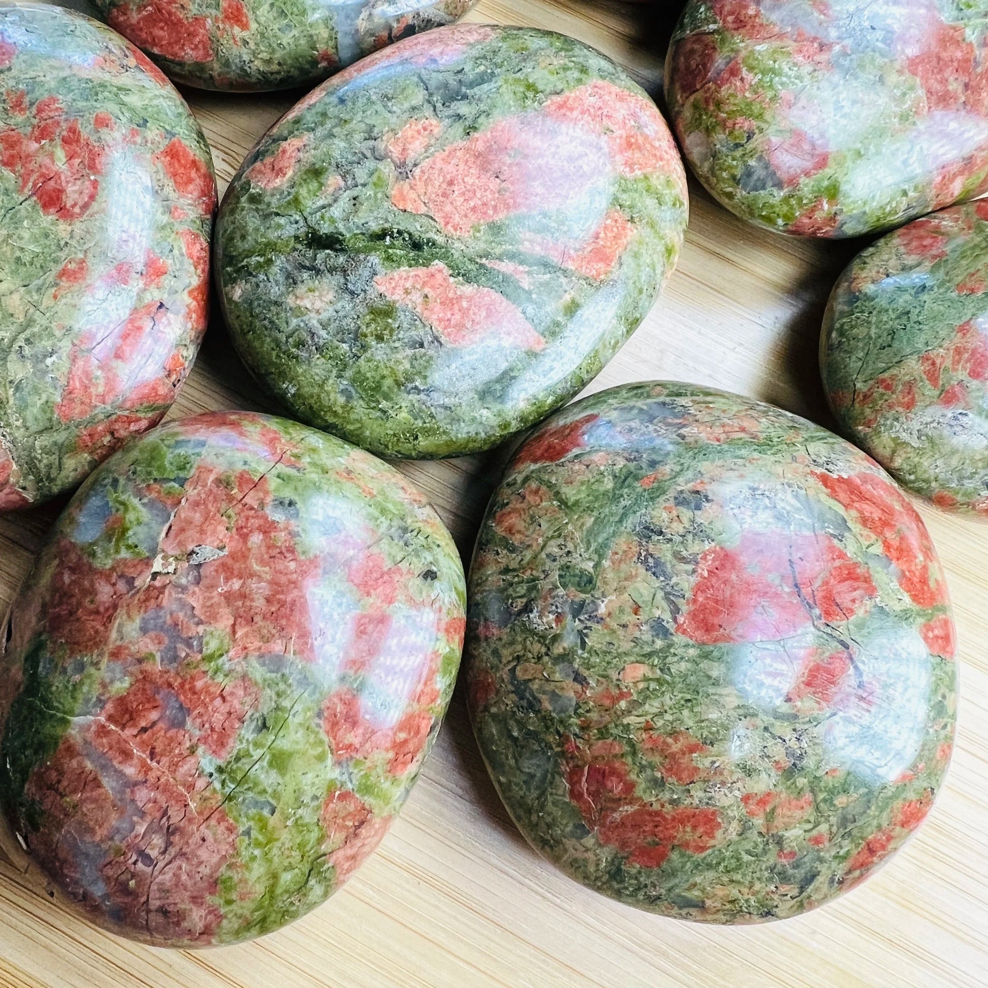 Top-down shot of Unakite palm stone, showing natural inclusions, sourced from South Africa.