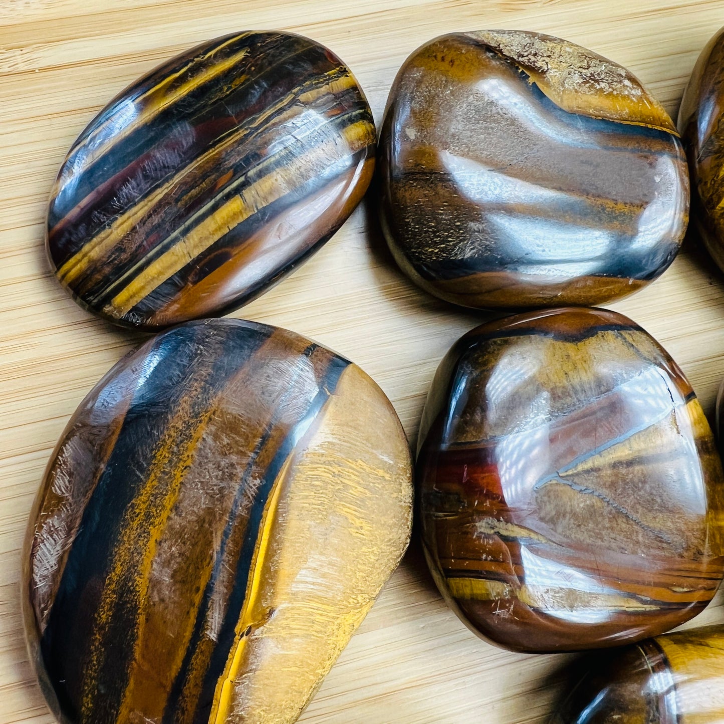 Side-on view of Grade AA Tiger Eye palm stone, kept near for Confidence, South Africa-sourced.