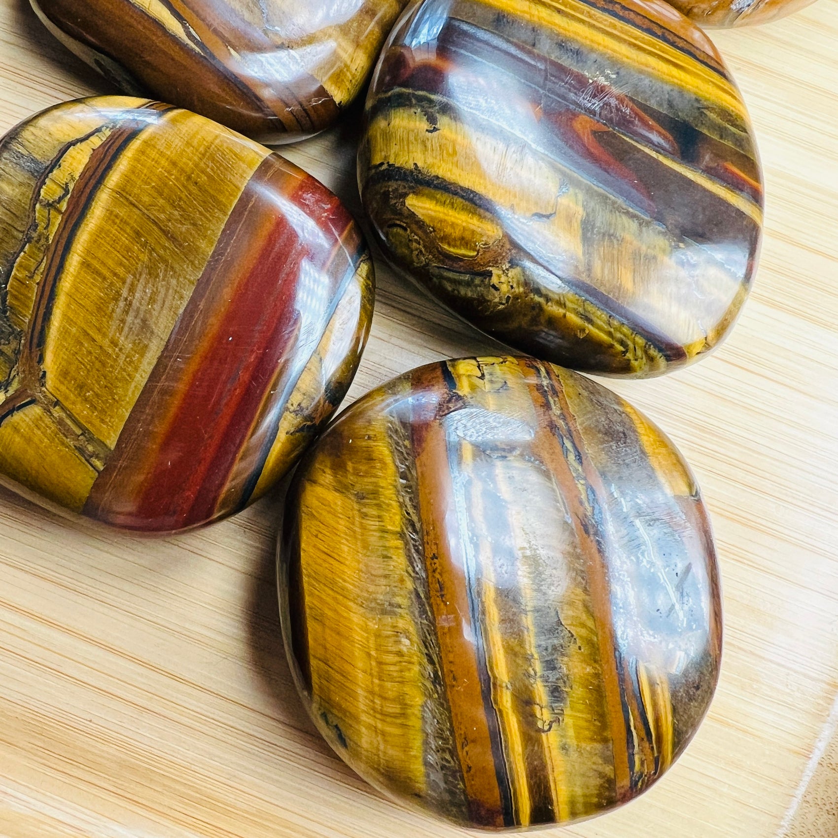 Plan view of Grade AA Tiger Eye palm stone, showing natural inclusions, South Africa-sourced.