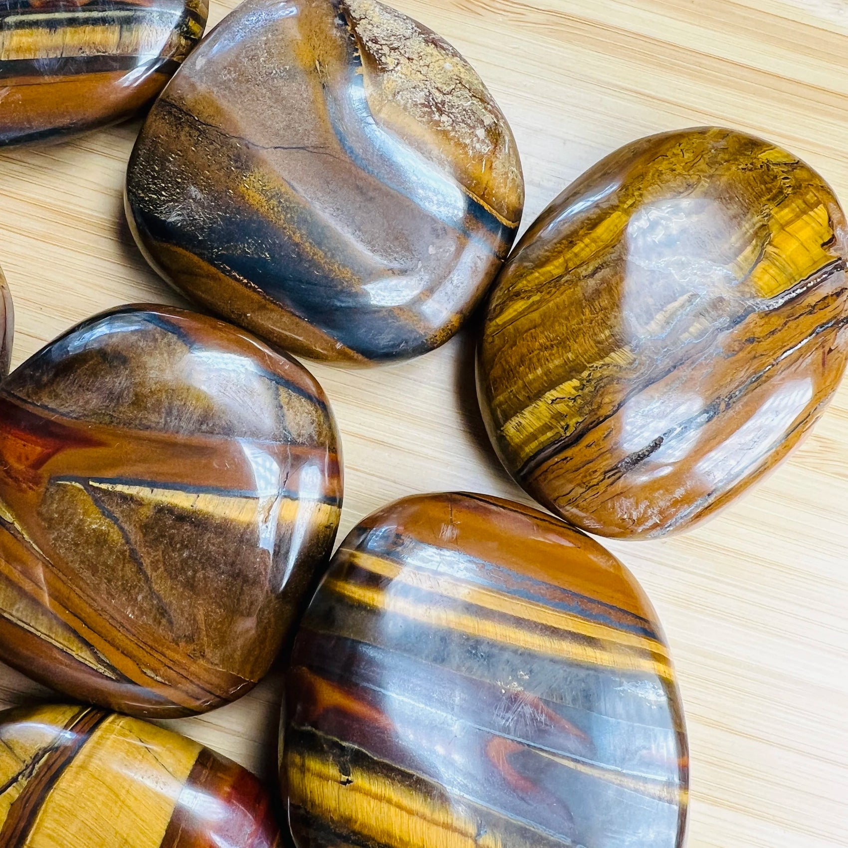 Underside view of brown Tiger Eye palm stone, often worked with for Confidence, sourced from South Africa.