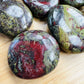 Color detail of Grade AA green Dragon Bloodstone palm stone, hand-selected from Limpopo, South Africa, drawn on for Confidence.