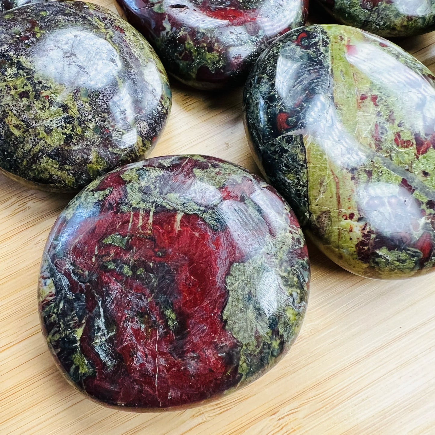Color detail of Grade AA green Dragon Bloodstone palm stone, hand-selected from Limpopo, South Africa, drawn on for Confidence.