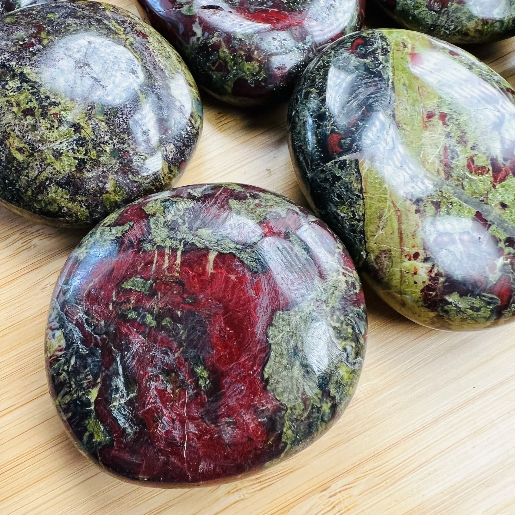 Color detail of Grade AA green Dragon Bloodstone palm stone, hand-selected from Limpopo, South Africa, drawn on for Confidence.