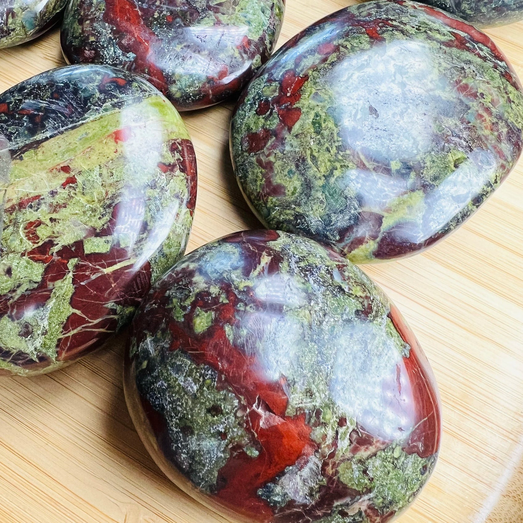 Overhead view of Dragon Bloodstone palm stone, hand-selected from Limpopo, South Africa, linked to Confidence.