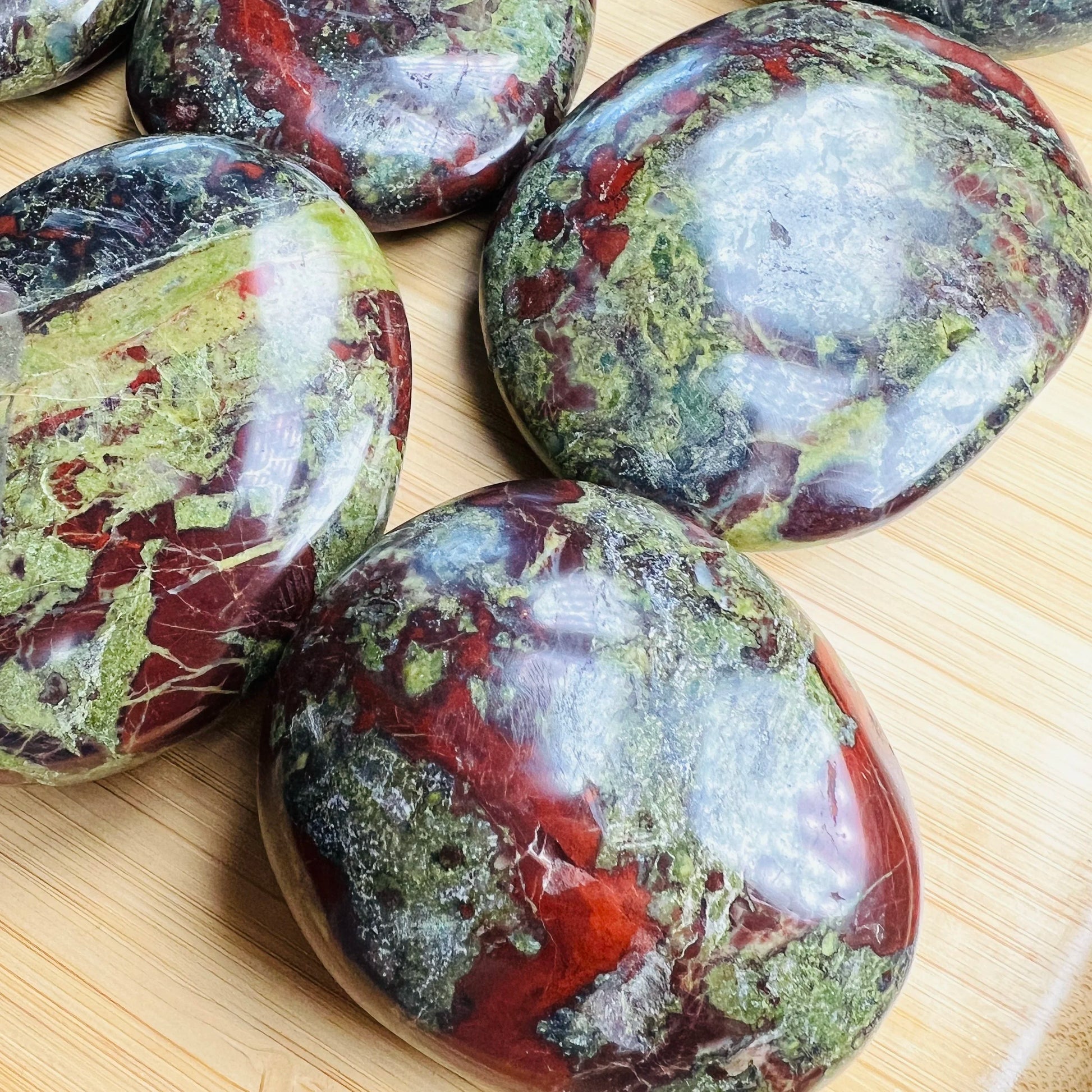 Overhead view of Dragon Bloodstone palm stone, hand-selected from Limpopo, South Africa, linked to Confidence.