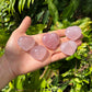 Edge view of pink Rose Quartz polished heart, showing color depth, Madagascar-sourced.