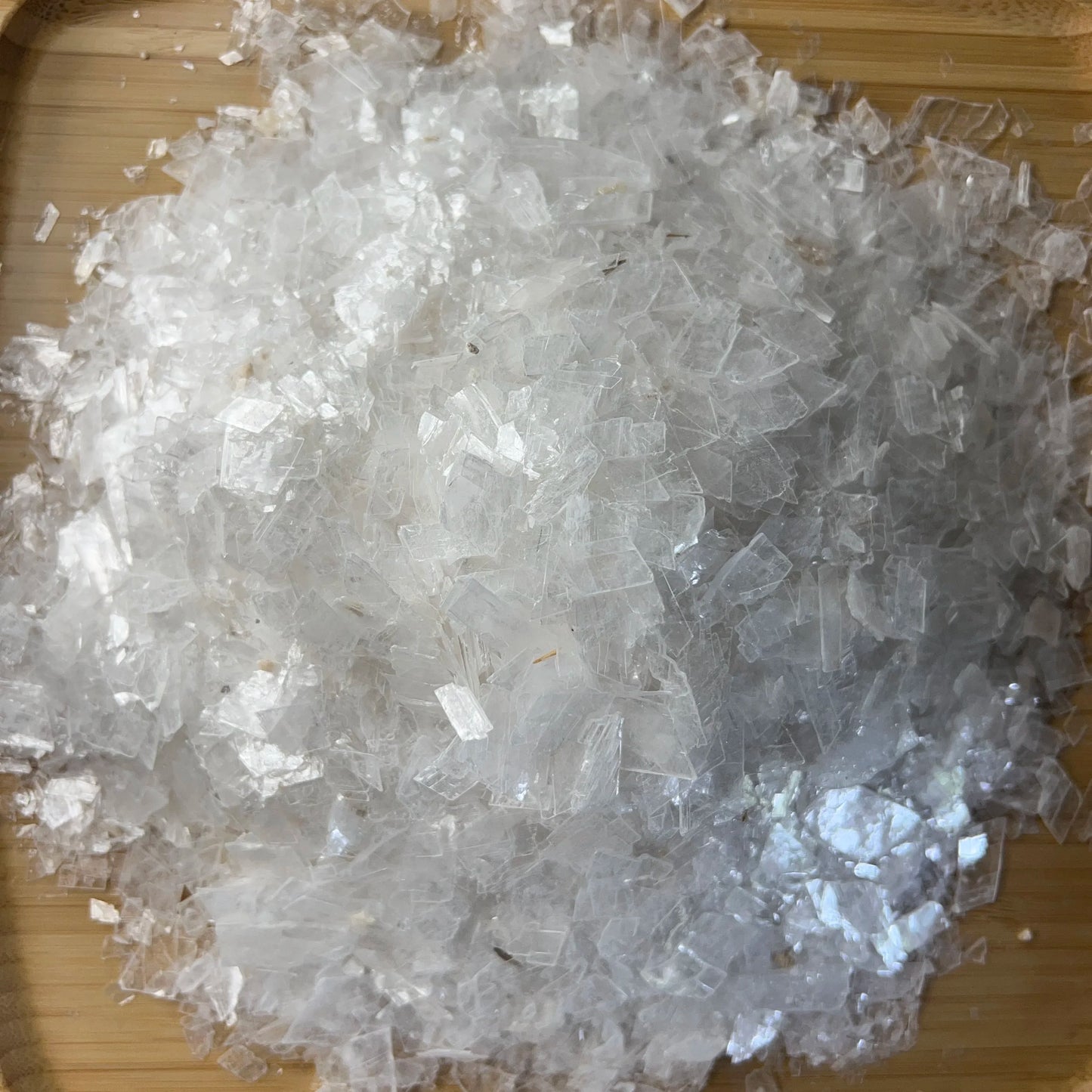 Sideways view of Selenite polished chip, showing glassy finish.