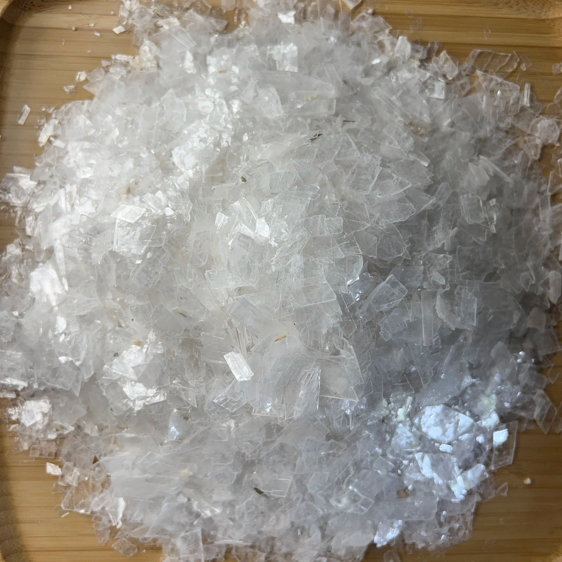 Sideways view of Selenite polished chip, showing glassy finish.