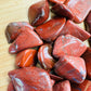 Side perspective of Red Jasper tumbled stone, carried for Grounding, showing characteristic finish.