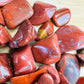 Underside detail of Red Jasper tumbled stone, traditionally used for Grounding and Energy, showing subtle veining.