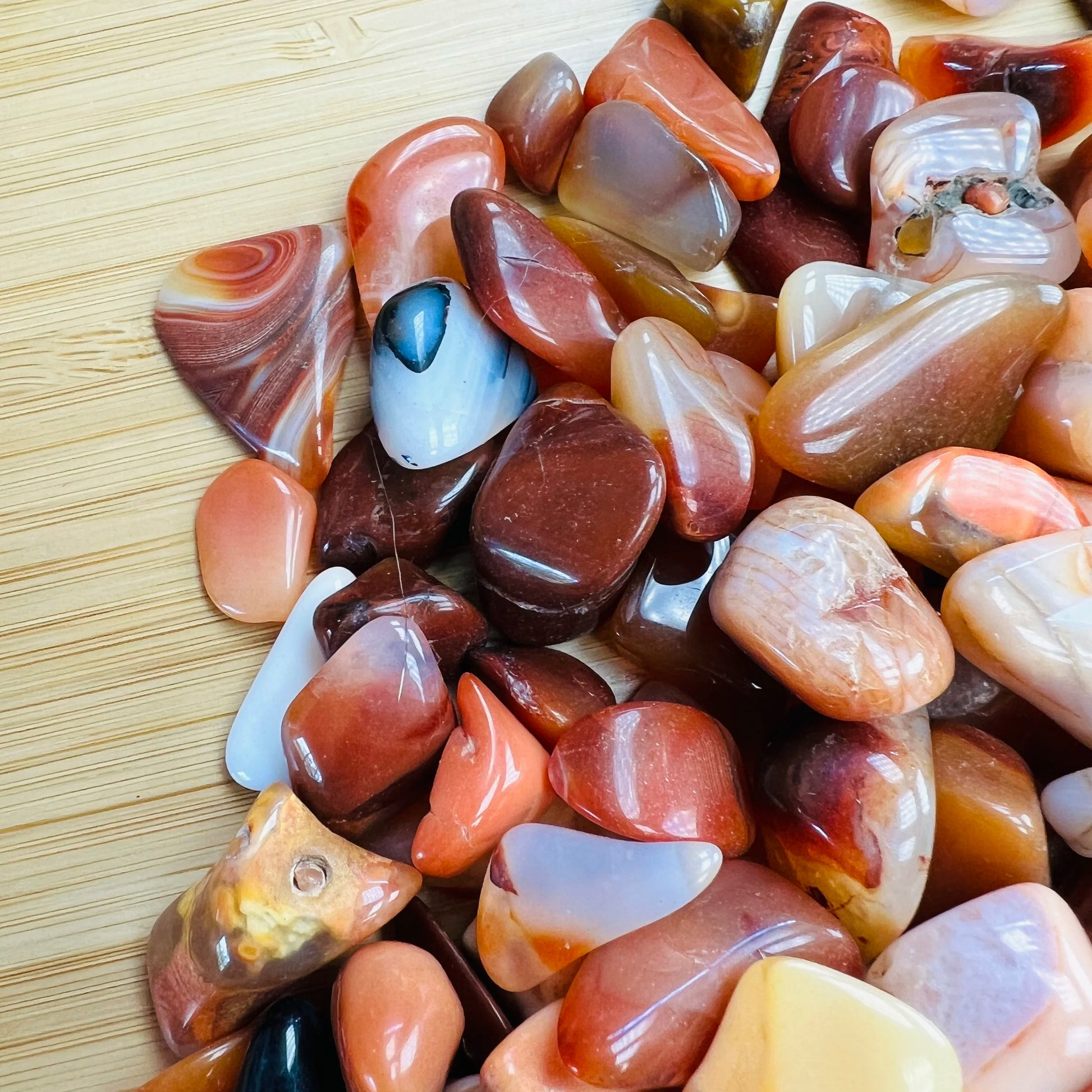 Side profile of Grade AA Carnelian tumbled stone with natural form and inclusions