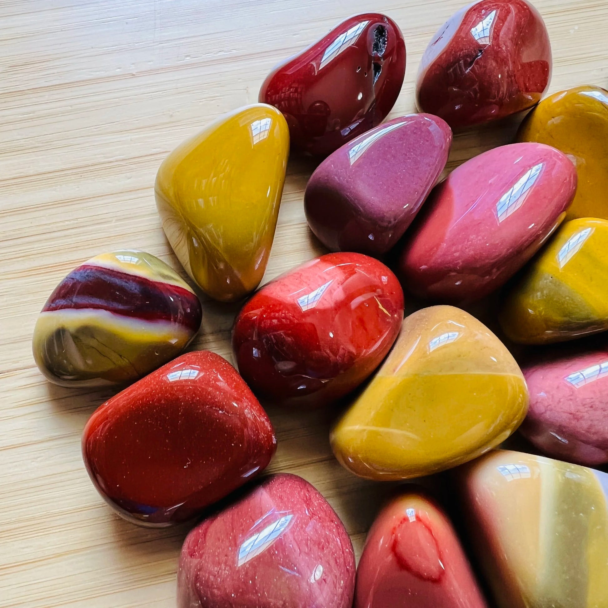 Side profile of Mookaite tumbled stone, hand-selected from Australia, showing natural variation.
