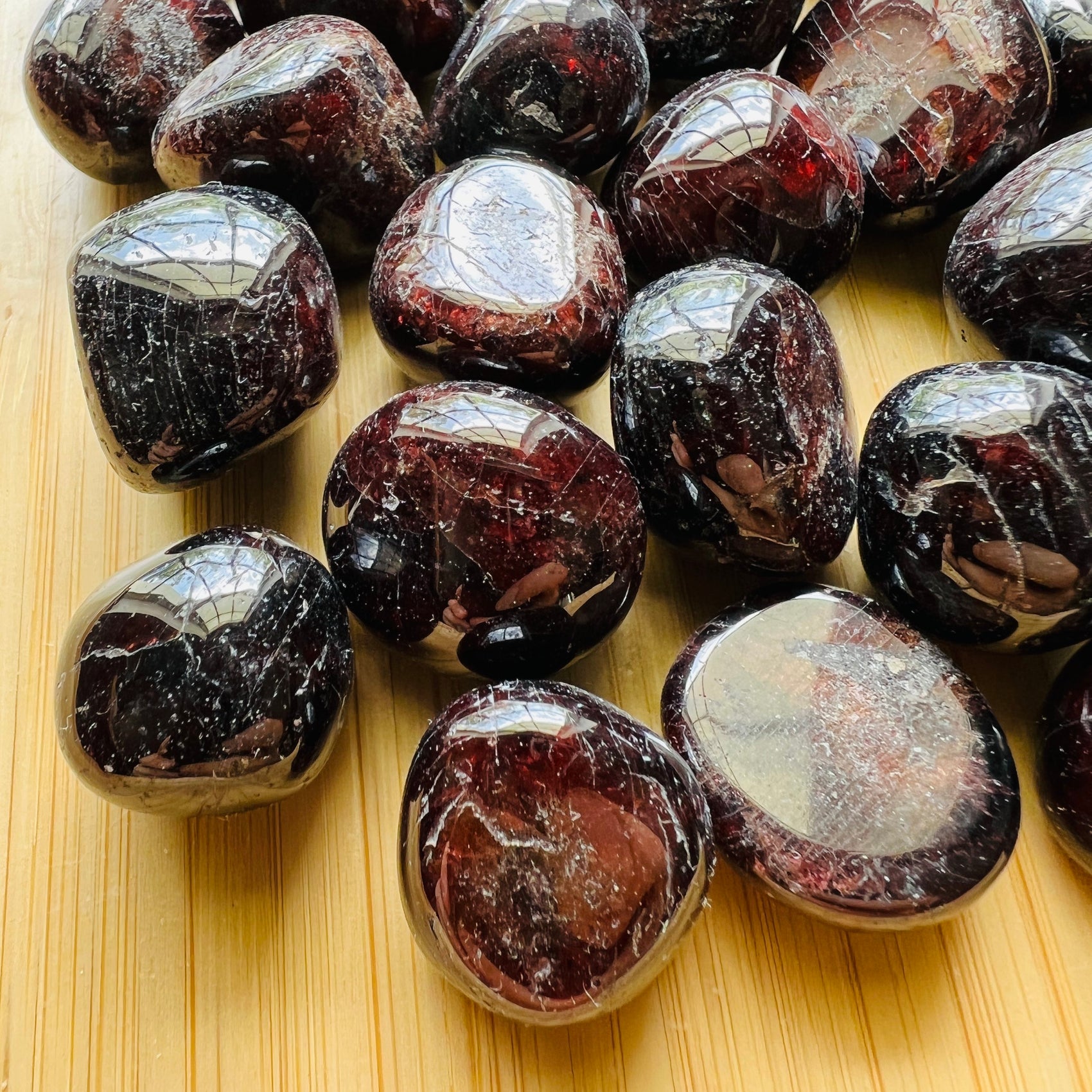 Near view of Grade AAA Garnet tumbled stone, linked to Energy.