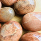 Bird's-eye view of Grade AA Peach Moonstone palm stone, traditionally used for Emotional Healing.