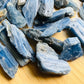Grade aa blue kyanite raw held in hand for size reference
