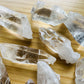 Three-quarter view of Clear Quartz raw crystal, from Arkansas, United States, associated with Healing, shown in a calm studio setting.