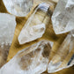 Side perspective of Clear Quartz raw point, sourced from United States, showing natural sheen.