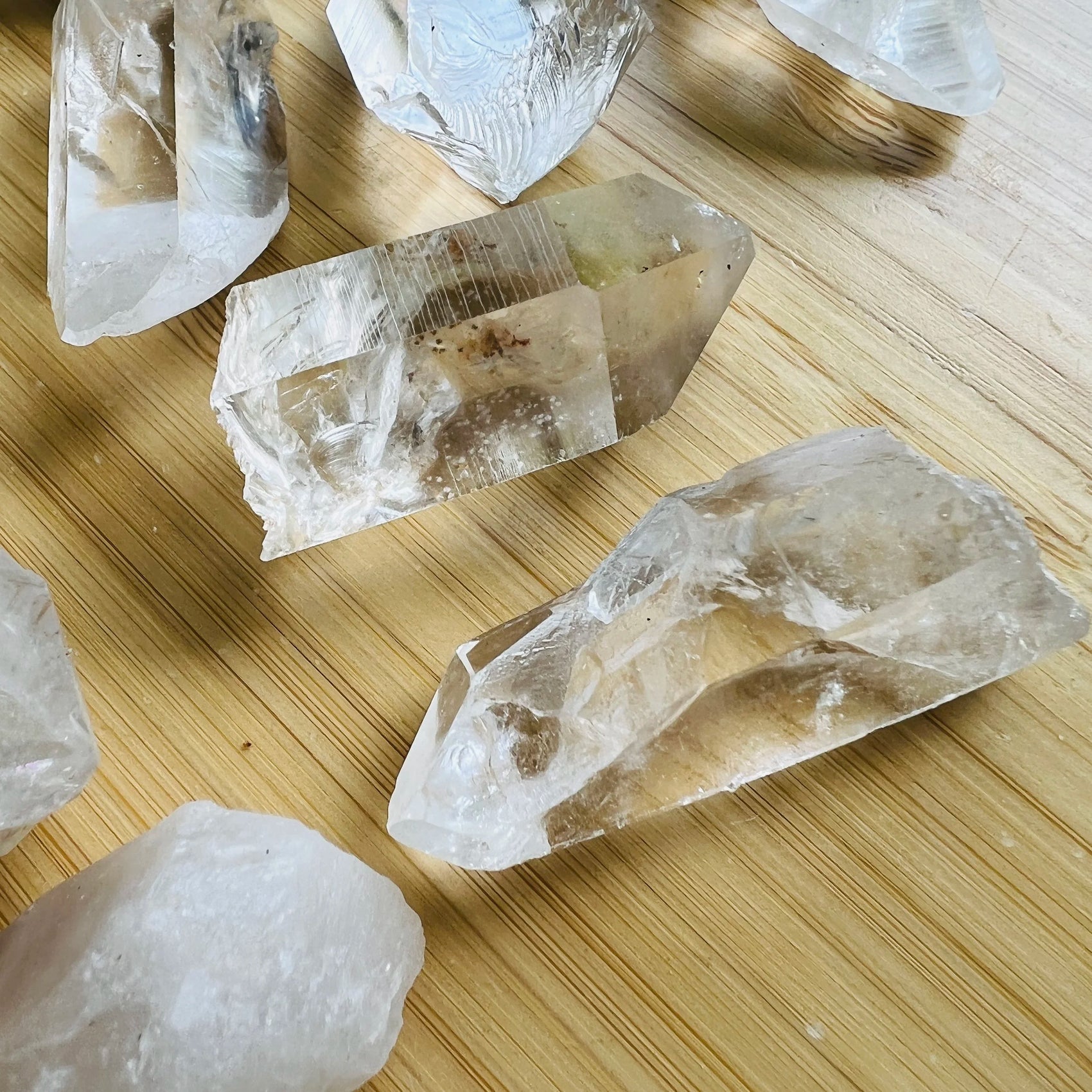 Lifestyle view of a Clear Quartz raw point held against natural backdrop.