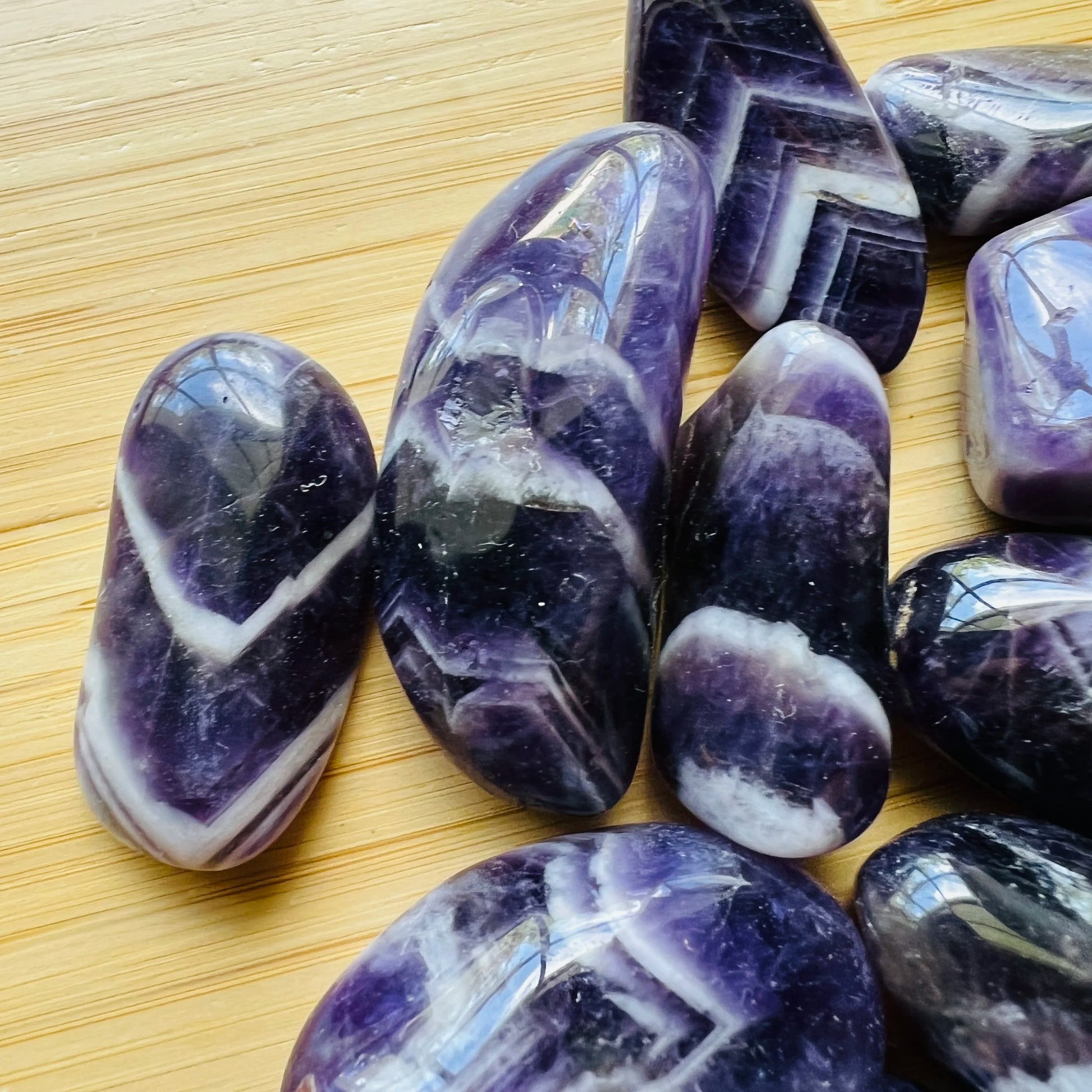 Lateral view of Chevron Amethyst tumbled stone, to support Intuition, showing characteristic color.
