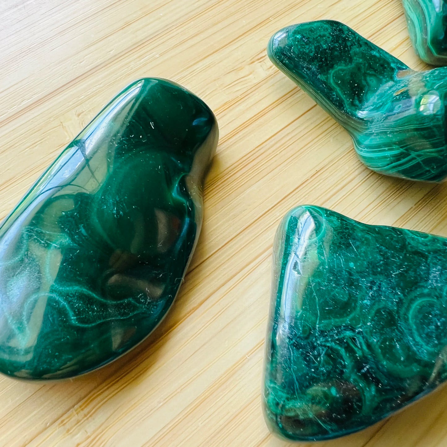 Back view of Grade AA Malachite tumbled stone showing natural surface