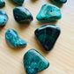 Detail shot of Grade AA Malachite tumbled stone under natural light