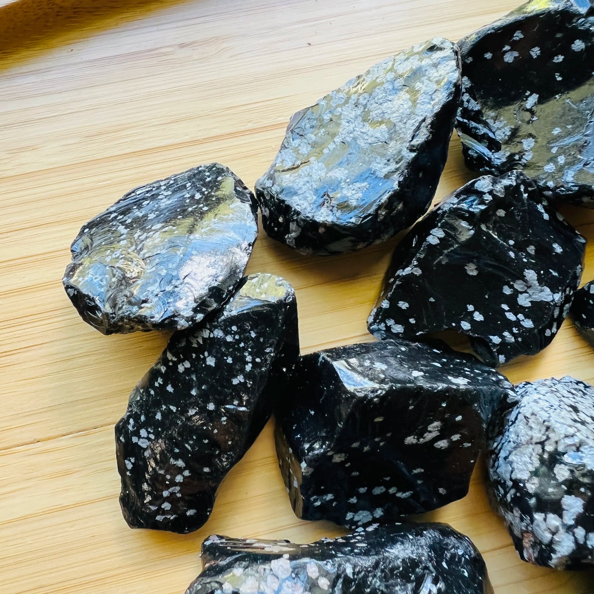 Grade aa snowflake obsidian raw held in hand for size reference
