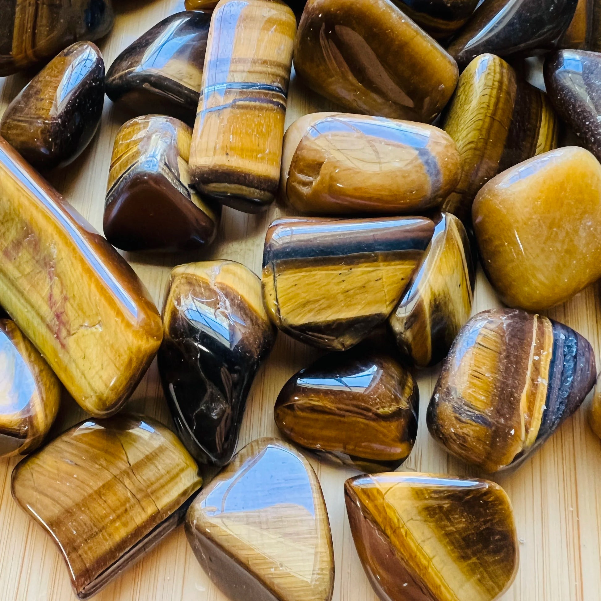 Detail shot of Grade A Tiger Eye tumbled stone under natural light