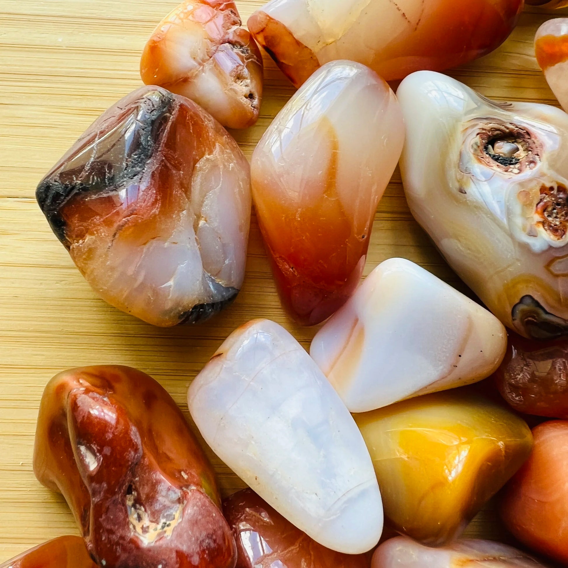 Grade aa carnelian tumbled stone held in hand for size reference