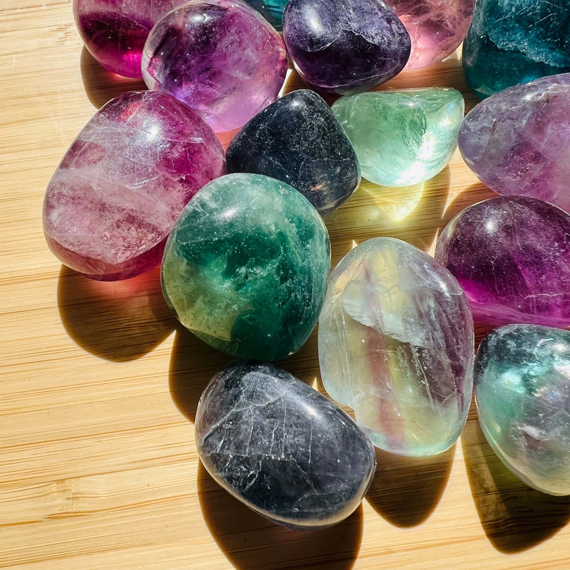 Side profile of purple Fluorite tumbled stone, turned to for Focus, showing glassy finish.