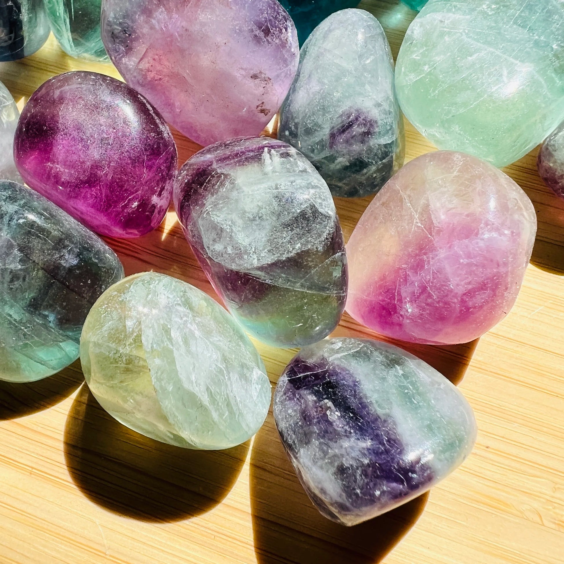 Bird's-eye view of Grade AA purple Fluorite tumbled stone, kept near for Focus and Meditation, showing natural inclusions.