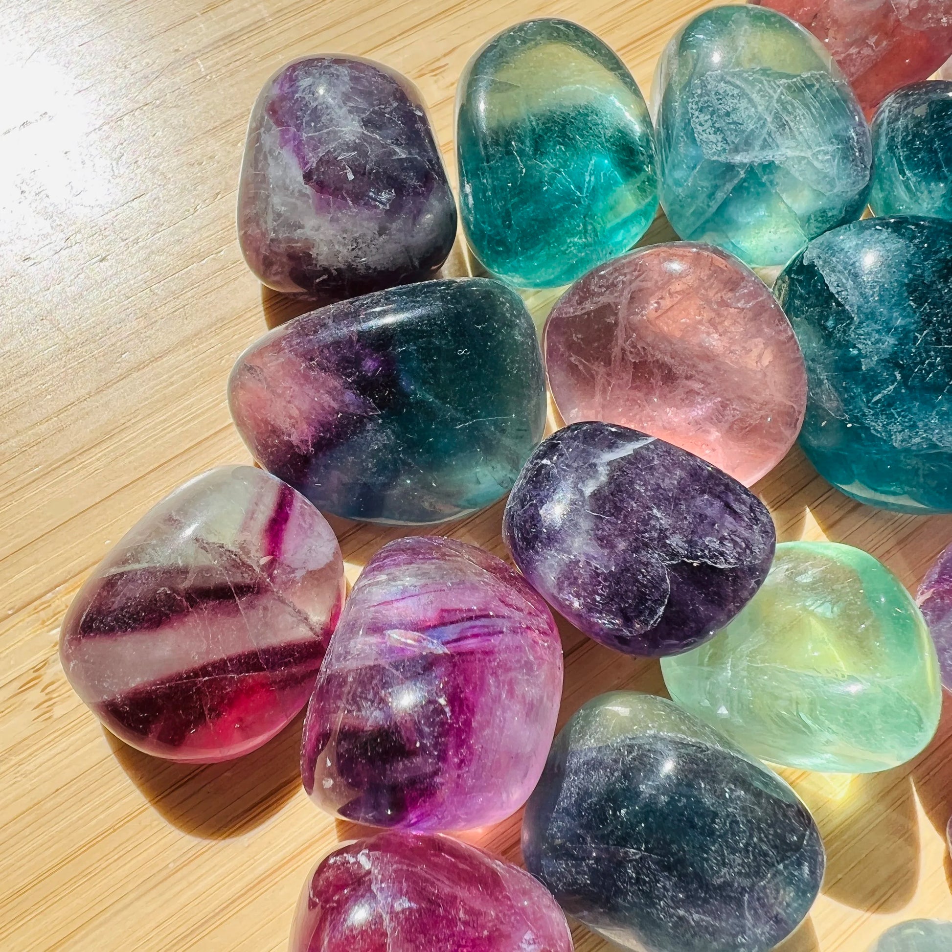 Hand-held view of one Fluorite tumbled stone for scale, hand-selected from Jiangxi, China.