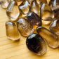 Detail capture of brown Smoky Quartz tumbled stone, showing natural inclusions, kept close for Grounding.
