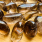 Edge view of Smoky Quartz tumbled stone, showing characteristic color, sourced from Brazil.