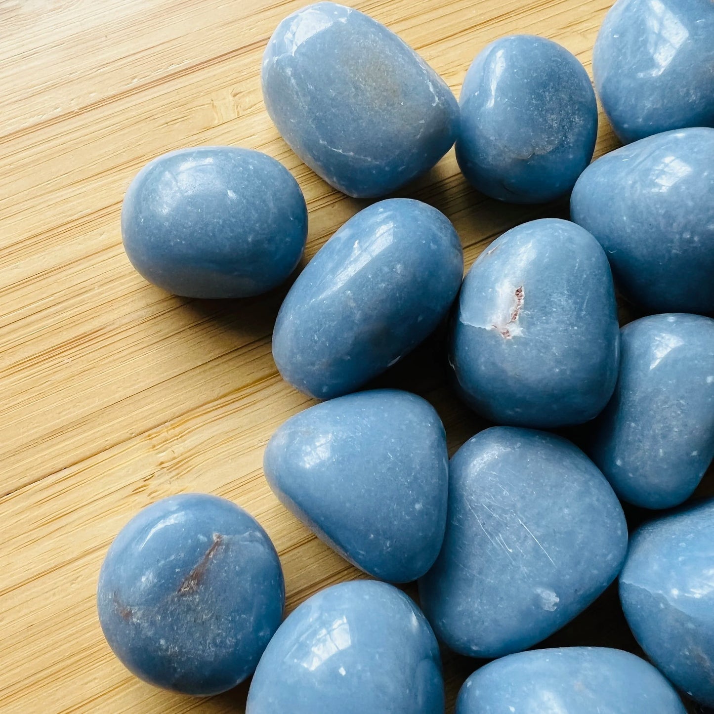 Close detail of blue Angelite tumbled stone, showing glassy finish.