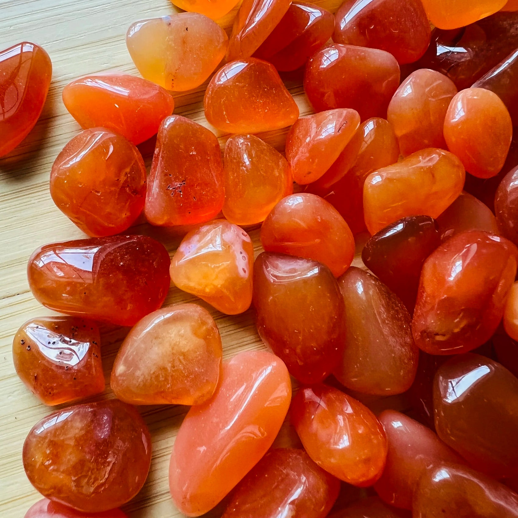 Sideways view of Carnelian tumbled stone, kept near for Energy and Confidence, showing color depth.