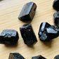 Close-up detail of Grade AA Black Tourmaline raw showing natural black tones and texture