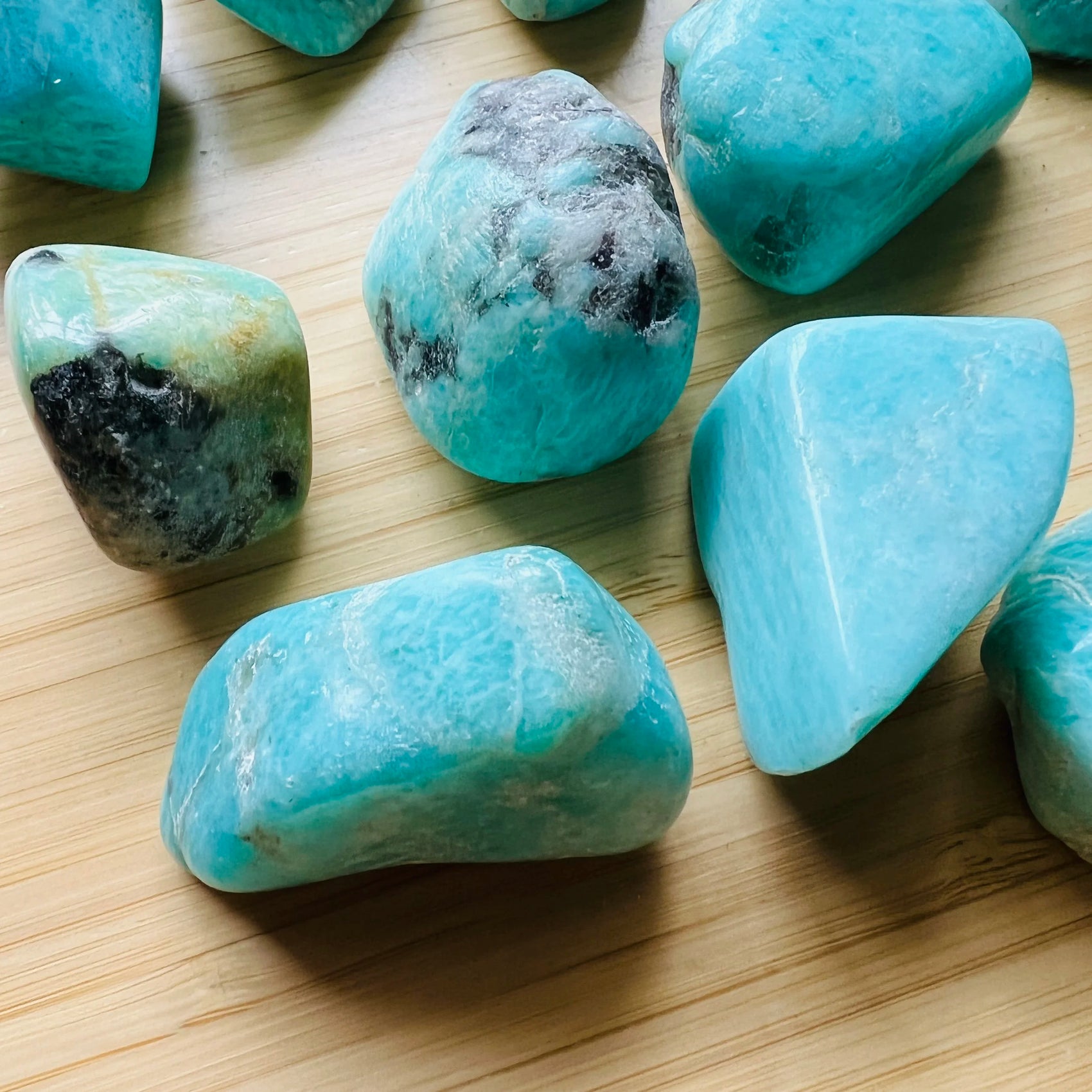 Grade aa amazonite tumbled stone held in hand for size reference