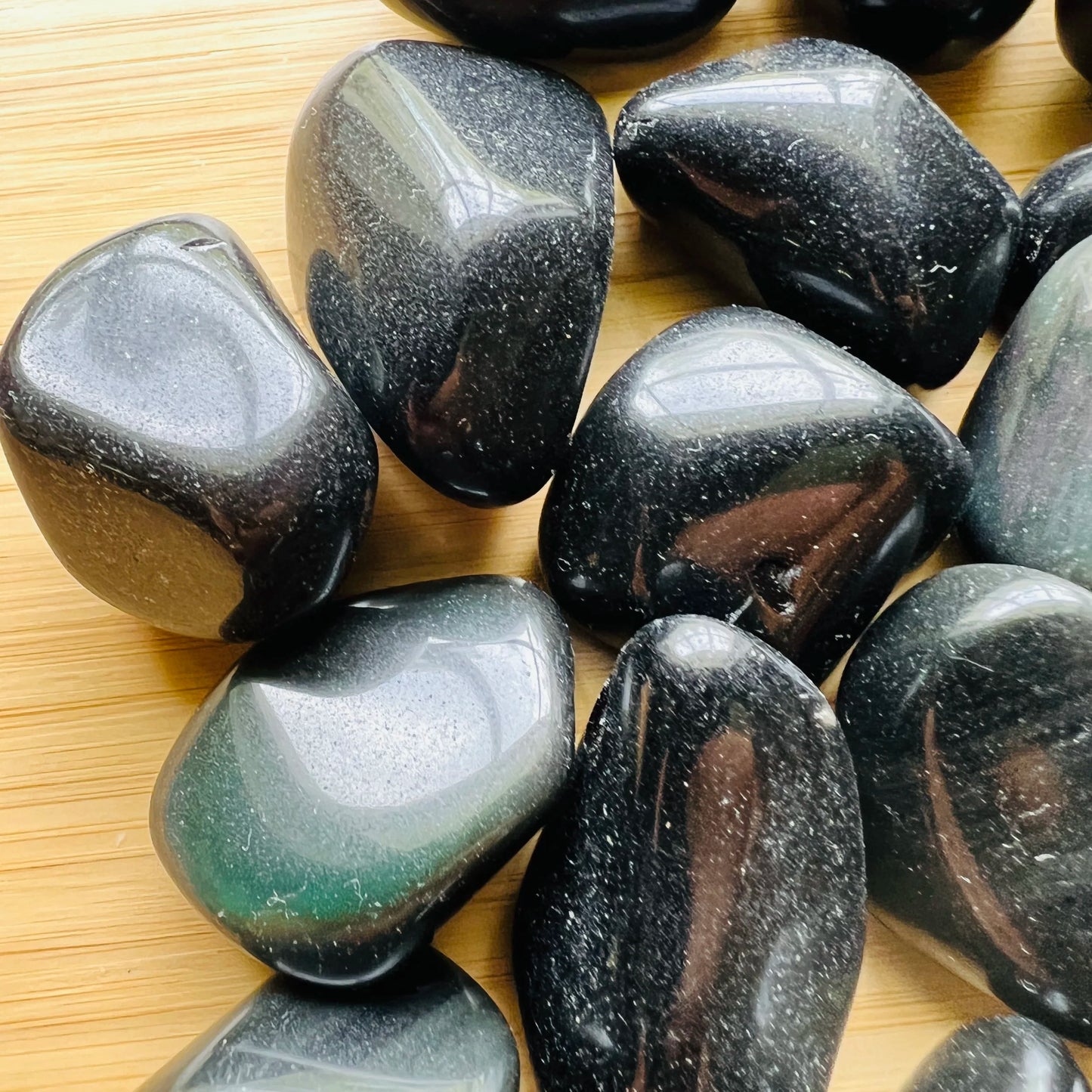 Profile view of Rainbow Obsidian tumbled stone, from Mexico, often paired with practices around Emotional Healing.