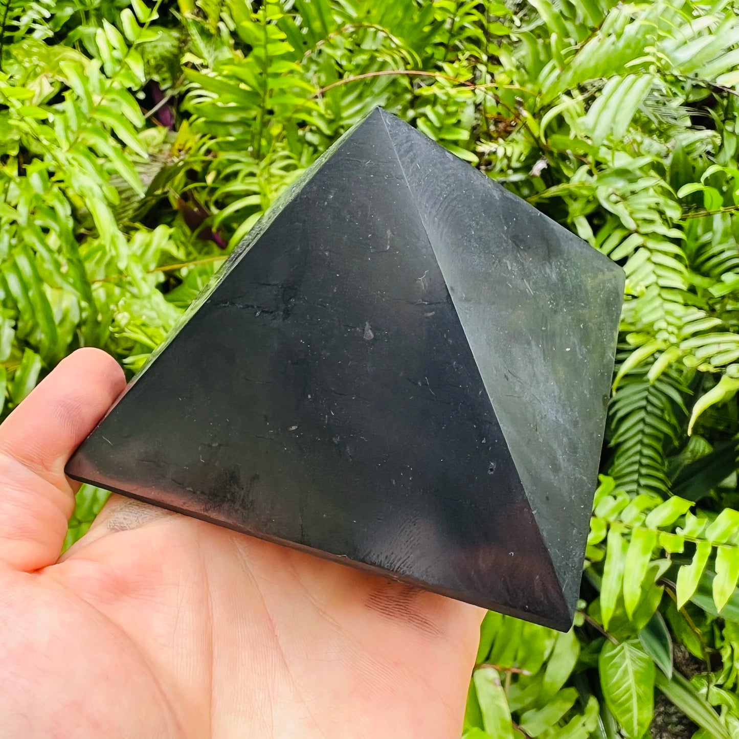 Top-down shot of Shungite polished pyramid, traditionally used for Protection and Cleansing, sourced from Russia.