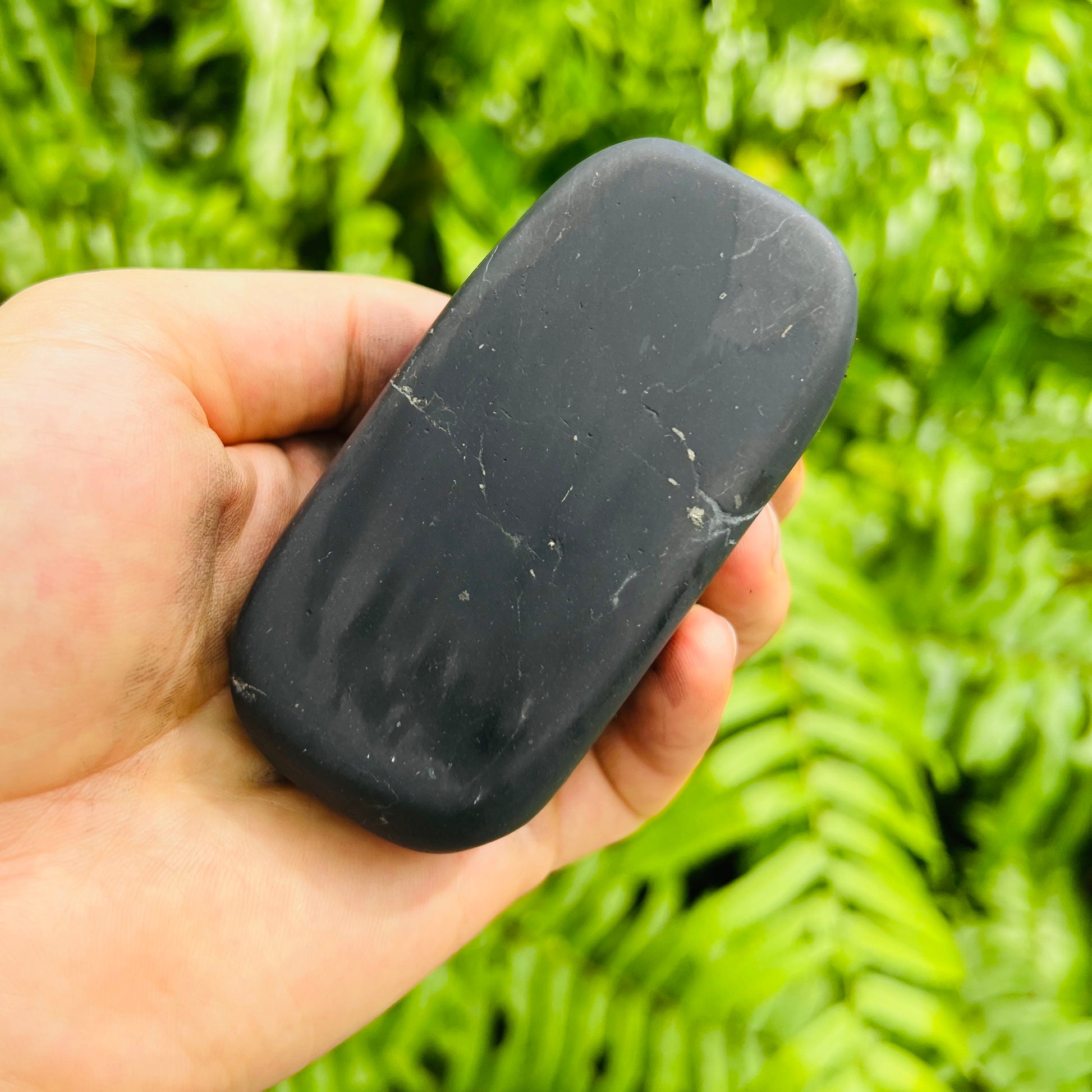Sideways view of Shungite palm stone, from Republic of Karélia, Russia.