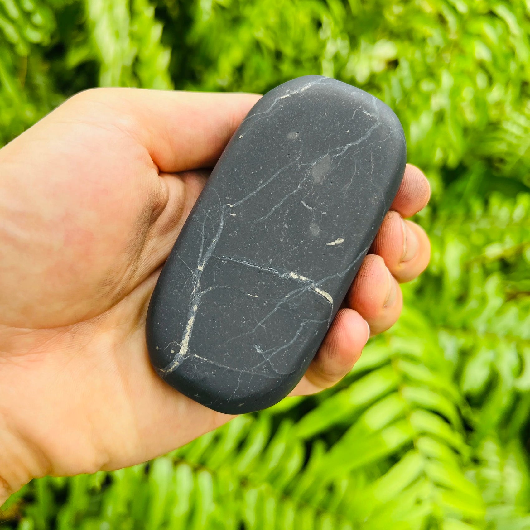 Looking down on Shungite palm stone, showing glassy finish, often kept for Protection.
